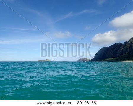 Gentle wave in Waimanalo Bay looking towards Rabbit island and Rock island on nice day Oahu Hawaii. August 2015..