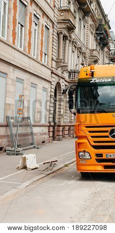 STRASBOURG FRANCE - MAY 18 2016: Half of Mercedes-Benz Actros 2660 truck transporting construction excavator at the construction site in urban environment during roadwork