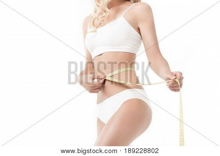Cropped View Of Slim Woman In Underwear Measuring Her Waistline Isolated On White