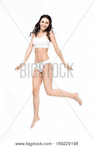 Smiling Young Woman With Perfect Body In White Underwear Jumping