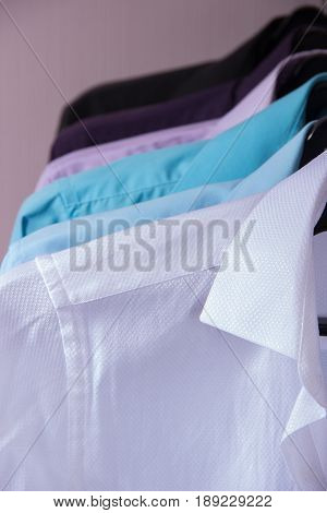 colored men's shirts that hang on black hangers