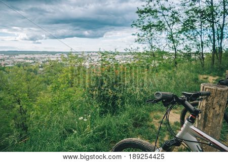 two bicycles stand on hill wth city view on background