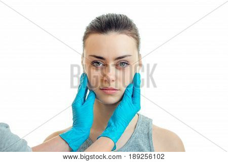 horizontal portrait of a young girl on the serious doctor with blue mittens isolated on white background