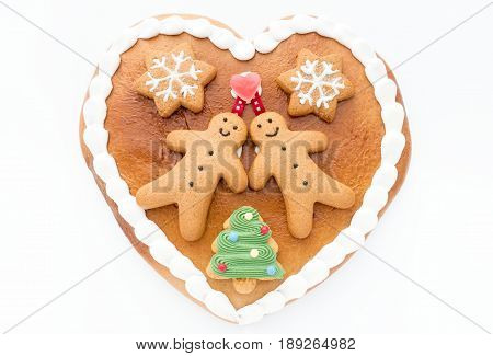 Close up of a cute Gingerbread heart decorated with Gingerbread Men Gingerbread Stars and a Christmas Tree Cookie on white background.