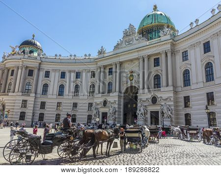 VIENNA AUSTRIA - MAY 28 2017: Traditional Coachman and two decorated horses called Fiaker waiting for tourists at central street of Vienna Austria.