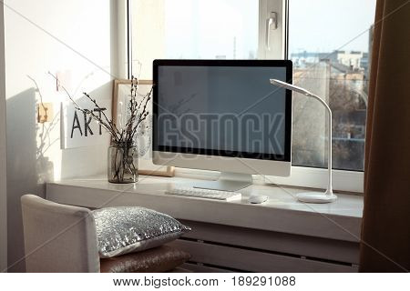 Creative workplace with monitor on windowsill in modern room