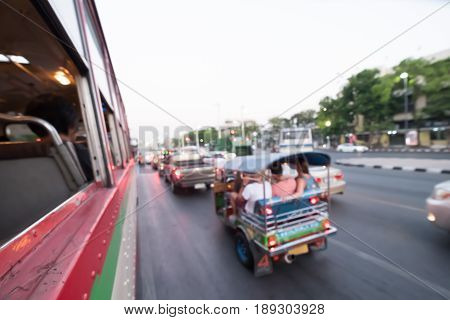 Blur Tuk Tuk in Bangkok take pictures from the buses in traffic jam. Auto rickshaw.