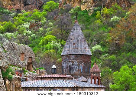 Architecture among green trees. Christian temple monastery GEGHARD (Armenia)