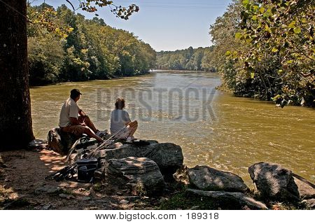 Couple Sitting Along River