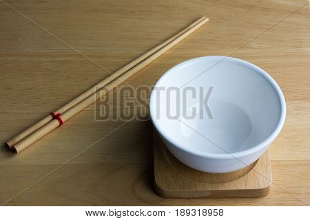 Empty ceramic white bowl isolated on the wood ground