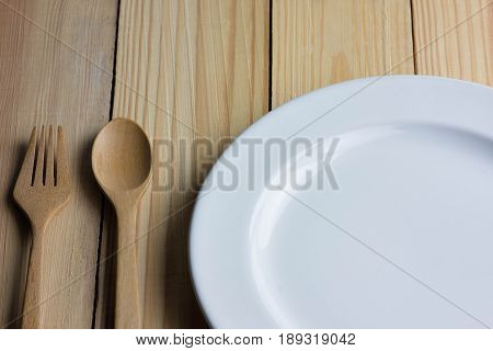 Empty white plate on the wooden table