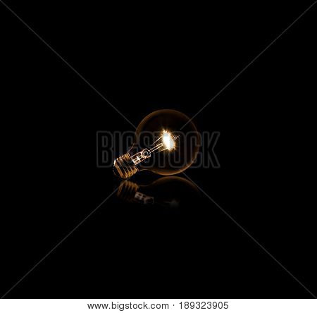 Lit light bulb on a black background