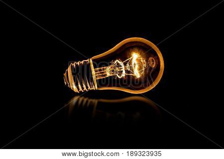 Lit light bulb light on a black background with room for print