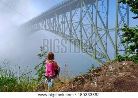 Woman meditating by ocean in foggy morning. Deception Pass Bridge Park. Seattle. Anacortes. Washington. United States.