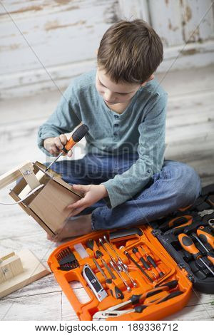 the boy opened the box with a hand tools and assemble on instructions a wooden table lamp