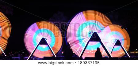 Defocused photo of The Freedom of Movement installation during Vivid Sydney. Bokeh Opera House in the background. Abstract Bokeh Night city lights background. Soft focus with long exposure.