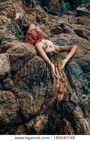 beautiful young woman in red dress laying dowm in water