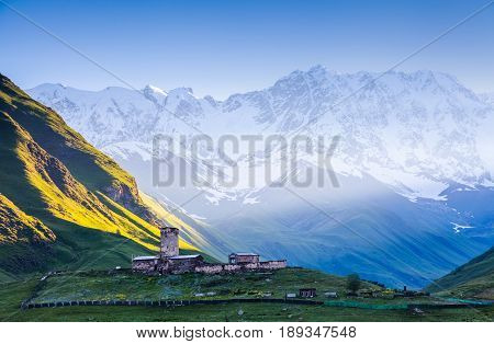 View on Ushguli village at the foot of snow-capped Mt. Shkhara. Location place Lamaria Church Jgrag Upper Svaneti Georgia Europe.
