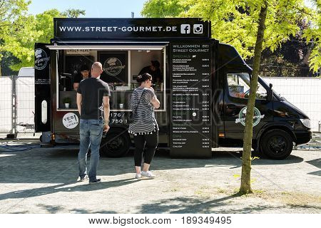 SCHWERIN GERMANY JUNE 2 2017: Mobile kitchen in a black food truck selling gourmet burger during the international street food festival weekend in the city on the market place