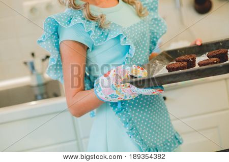 cupcakes are on the tray. Female hands holding dessert.Multi-colored cakes