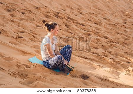 Young Woman Rolls On A Toboggan In The Sledge In The Desert