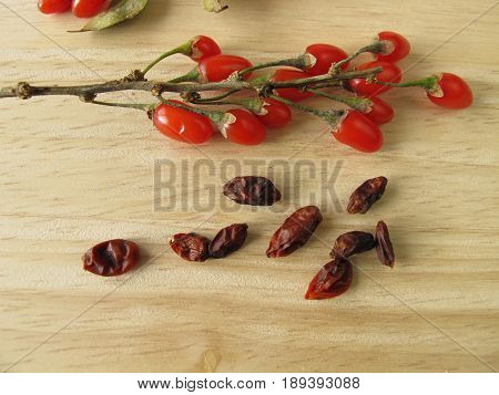 Fresh and dried goji berries on wooden board