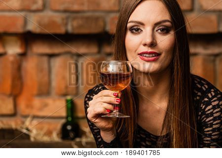 Woman Tasting Wine In Rural Cottage Interior
