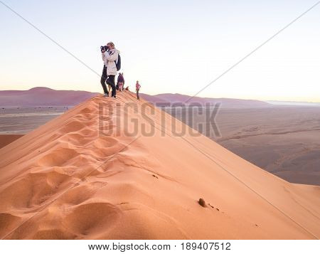 SOUSSUSVLEI NAMIBIA - JUNE 20 2016: People watching sunrise form the Dune 45 in the Sossusvlei area of the Namib Desert in Namibia.