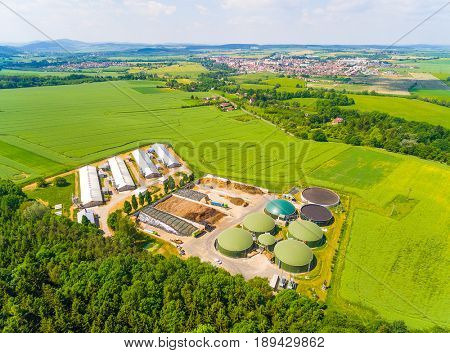 Aerial view over biogas plant and farm in green fields. Renewable energy from biomass. Modern agriculture in Czech Republic and European Union. 