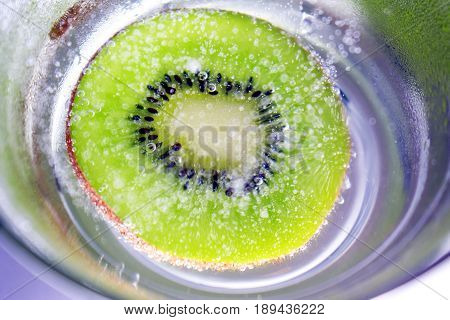 Sliced Kiwi Dropped in a Glass of Fizzy Water
