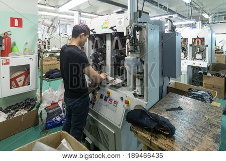 MOSCOW, RUSSIA - FEBRUARY 21, 2017: Moscow shoe factory JSC RALF RINGER. A male worker is working on a shoe molding machine.
