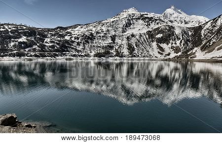 Alpine lake in the Formazza valley with blue sky and snowy mountains in a spring sunny day Piedmont - Italy