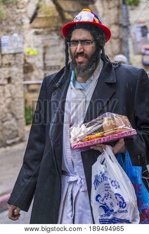 JERUSALEM - MARCH 13 : Ultra Orthodox man holding Mishloach Manot during Purim in Mea Shearim Jerusalem on March 13 2017 Mishloach Manot is traditional food gifts given during Purim