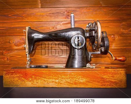 The old sewing machine on wooden background.