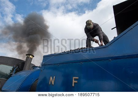 DARJEELING INDIA - NOVEMBER 27 2016: technician services the steam engine hauled DHR Toy Train used for joy ride tours as well as regular transport services in Darjeeling.