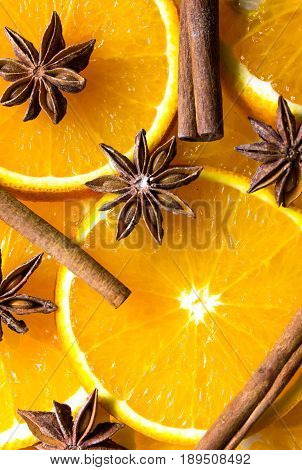 bright orange background from slices of juicy oranges with anise stars cinammon