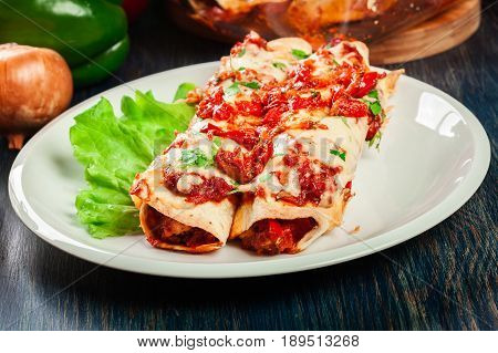 Traditional Mexican Enchiladas With Chicken Meat, Spicy Tomato Sauce And Cheese On A Plate