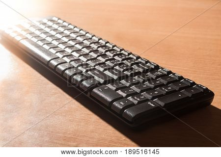 Computer black keyboard isolated on wood background.