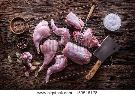 Rabbit. Raw rabbit slices with spices garlic kitchen utensilfork and butcher. Hunting cuisine.