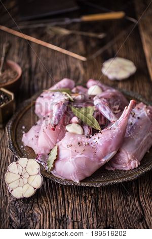 Rabbit. Raw rabbit slices with spices garlic kitchen utensilfork and butcher. Hunting cuisine.