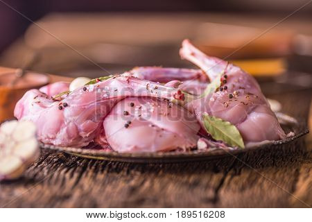 Rabbit. Raw rabbit slices with spices garlic kitchen utensilfork and butcher. Hunting cuisine.