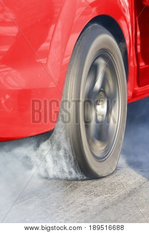 Race car burns rubber off its tires in preparation for the race