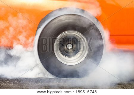 Race car burns rubber off its tires in preparation for the race