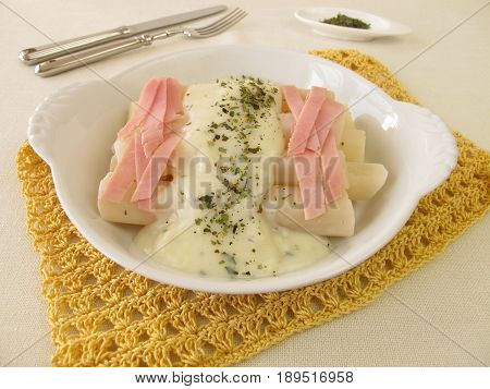 Black salsify roots with bechamel sauce and cooked ham