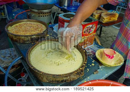 Kota Kinabalu,Sabah-May 28,2017:Street vendor preparing traditional Apam Balik or Terang Bulan cuisine at street bazaar in Kota Kinabalu,Sabah,Malaysia.It's a type of griddle pancake common in Brunei,Indonesia,Singapore & Malaysia.
