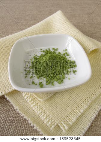 Ground matcha tea powder in small bowl
