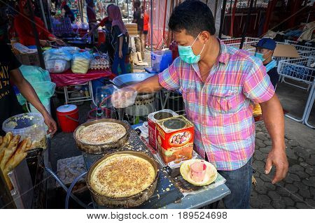 Kota Kinabalu,Sabah-May 28,2017:Street vendor preparing traditional Apam Balik or Terang Bulan cuisine at street bazaar in Kota Kinabalu,Sabah,Malaysia.It's a type of griddle pancake common in Brunei,Indonesia,Singapore & Malaysia.