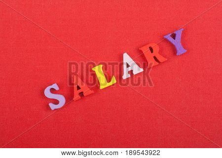 Word on red background composed from colorful abc alphabet block wooden letters, copy space for ad text. Learning english concept
