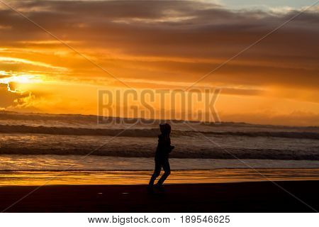 outdoor portrait of young happy smiling child girl in knitted hat on outdoor natural background