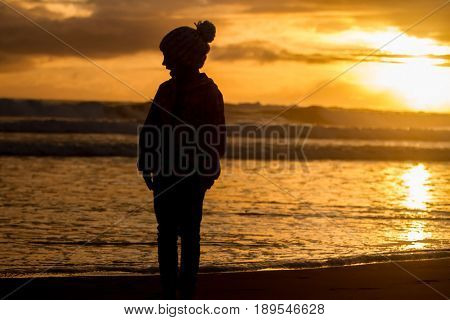 outdoor portrait of young happy smiling child girl in knitted hat on outdoor natural background